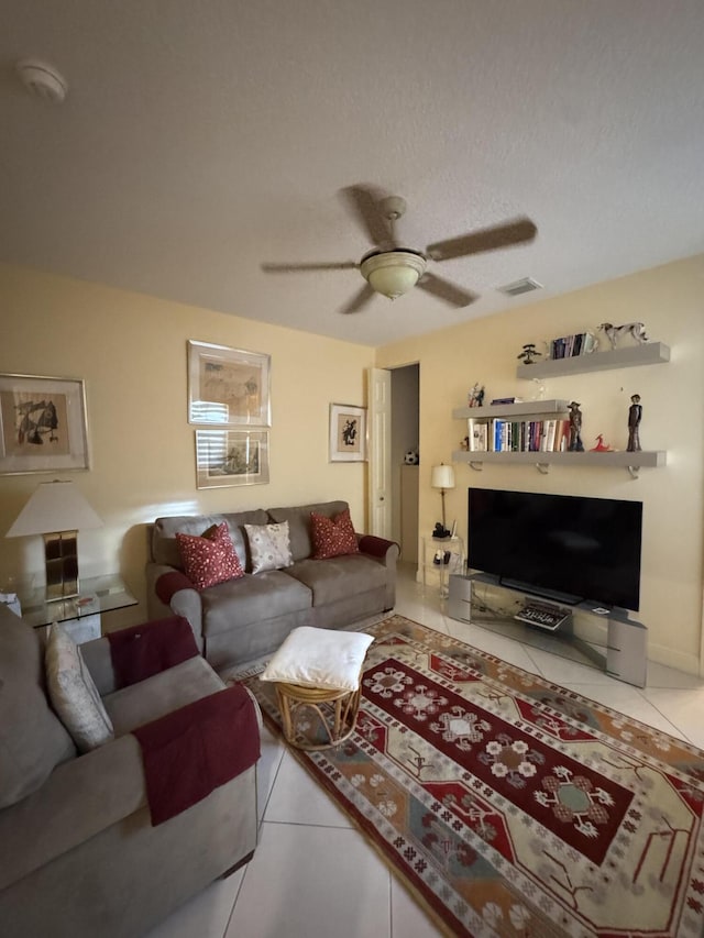 tiled living room with a textured ceiling and ceiling fan