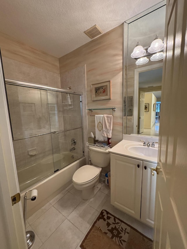 full bathroom with toilet, enclosed tub / shower combo, tile patterned floors, a textured ceiling, and vanity