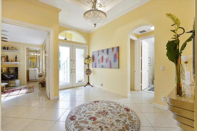 tiled entrance foyer featuring french doors and ornamental molding