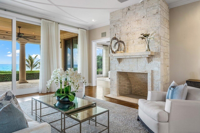 interior space featuring a water view, ceiling fan, and a stone fireplace