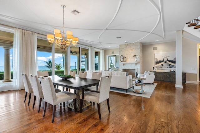 dining space with crown molding, a large fireplace, and dark hardwood / wood-style flooring