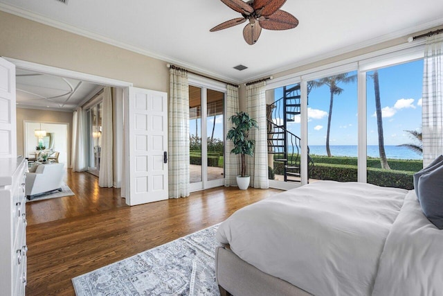 bedroom featuring crown molding, a water view, dark hardwood / wood-style floors, and access to exterior