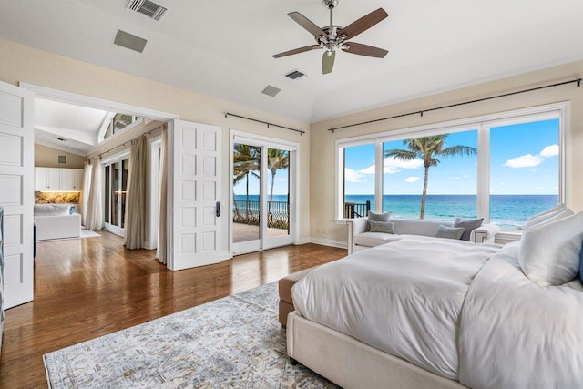 bedroom featuring lofted ceiling, access to exterior, a water view, a beach view, and dark hardwood / wood-style flooring