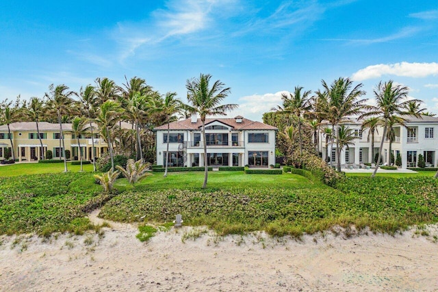 rear view of property with a water view and a lawn