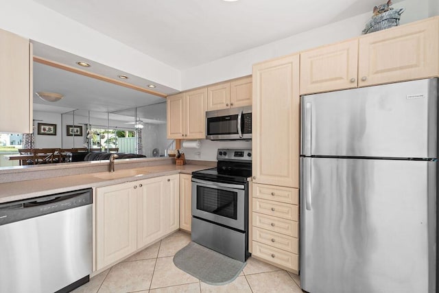 kitchen with sink, light tile patterned flooring, stainless steel appliances, and ceiling fan