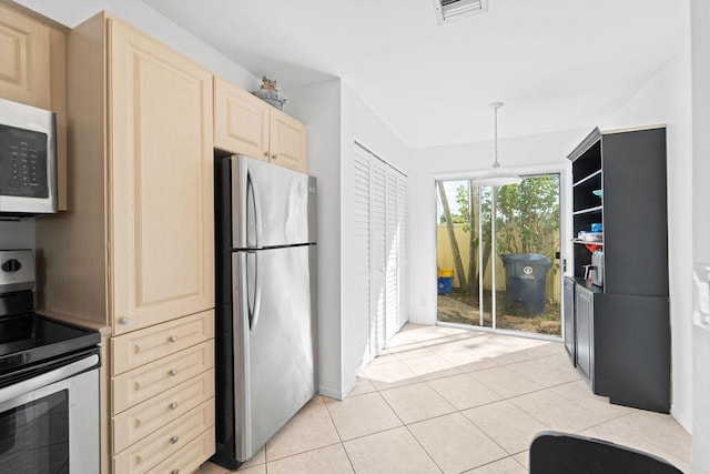 kitchen with light tile patterned flooring, stainless steel appliances, pendant lighting, and light brown cabinets