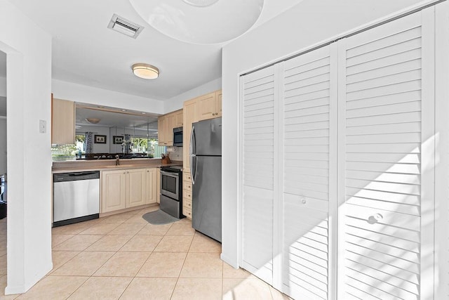 kitchen with light tile patterned floors, stainless steel appliances, and sink