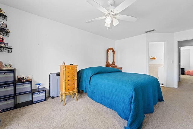 carpeted bedroom with ensuite bathroom and ceiling fan