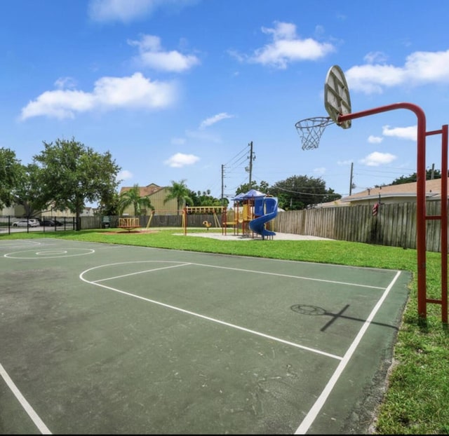 view of basketball court with a playground and a yard