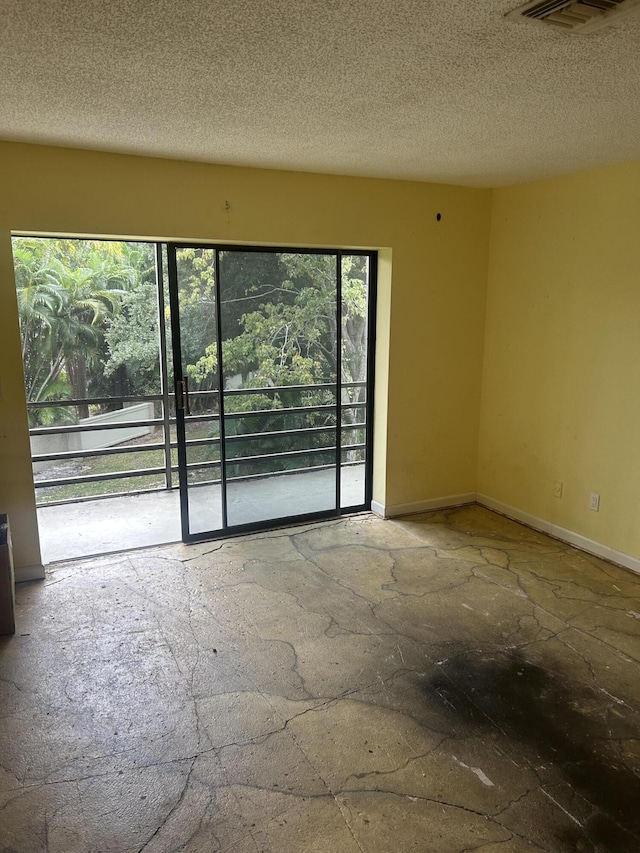 unfurnished room with plenty of natural light and a textured ceiling