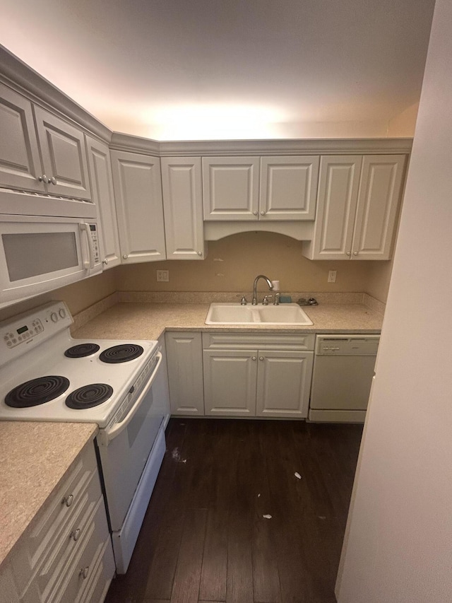 kitchen with dark hardwood / wood-style floors, sink, white appliances, and white cabinetry