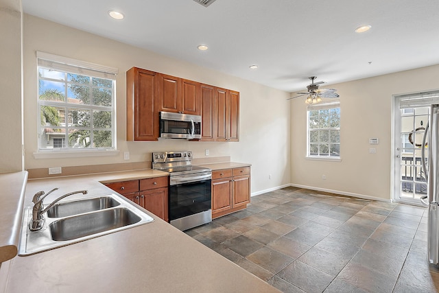 kitchen featuring ceiling fan, sink, and stainless steel appliances