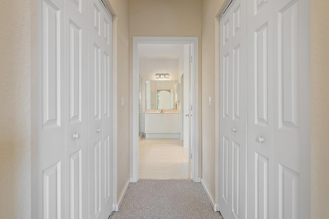 hallway with baseboards and carpet floors