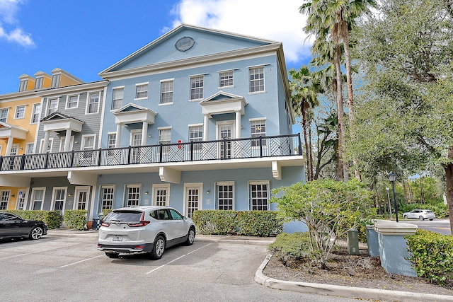 view of property featuring uncovered parking and stucco siding