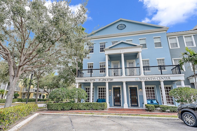 view of front facade with stucco siding and uncovered parking