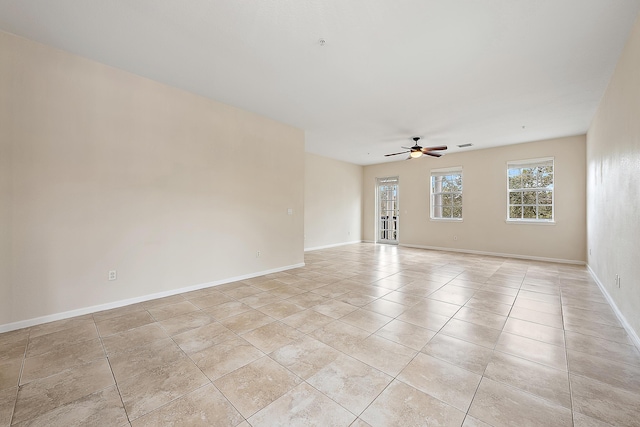 empty room with light tile patterned floors, visible vents, baseboards, and ceiling fan