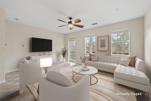 living area featuring light tile patterned flooring, visible vents, baseboards, and ceiling fan