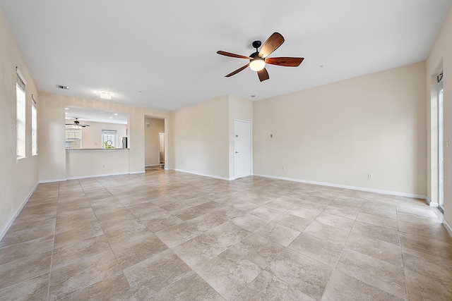 unfurnished living room featuring visible vents, a ceiling fan, and baseboards