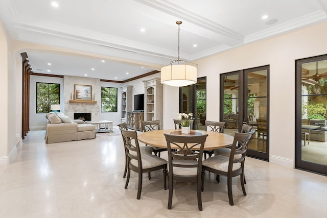 dining area with a fireplace, beamed ceiling, and ornamental molding