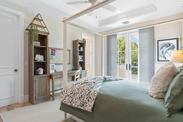 bedroom featuring ceiling fan, a raised ceiling, ornamental molding, and light hardwood / wood-style flooring