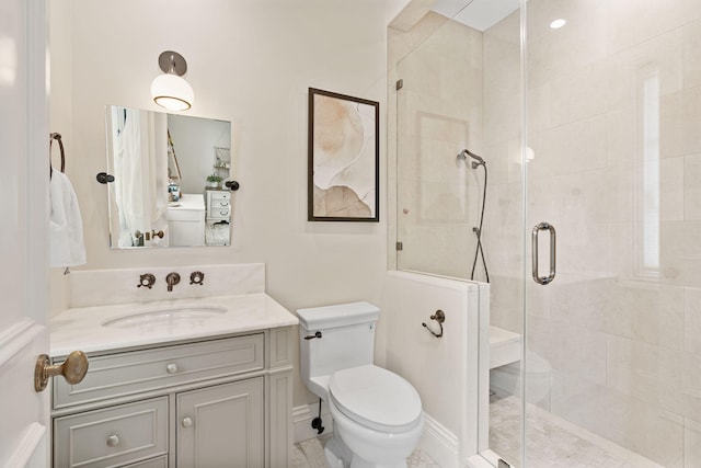 bathroom with a shower with shower door, toilet, and vanity