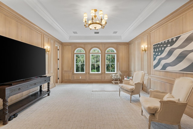 sitting room featuring an inviting chandelier, crown molding, and a raised ceiling