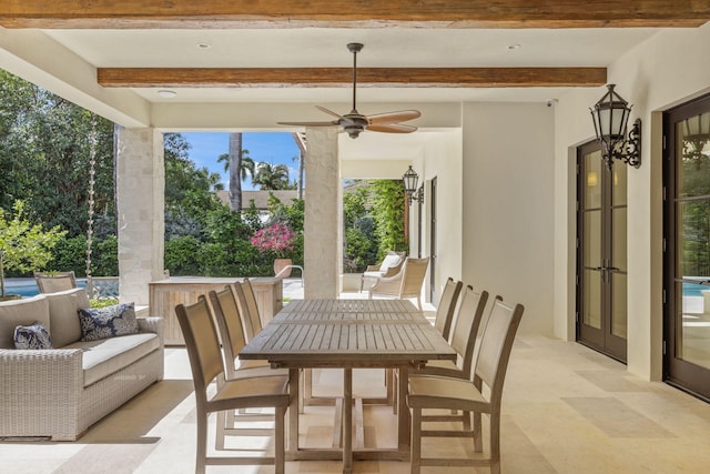 sunroom / solarium featuring ceiling fan and beamed ceiling