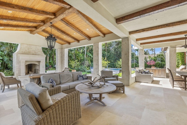 view of patio / terrace with ceiling fan and an outdoor living space with a fireplace