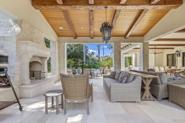 view of patio / terrace featuring ceiling fan and an outdoor living space with a fireplace