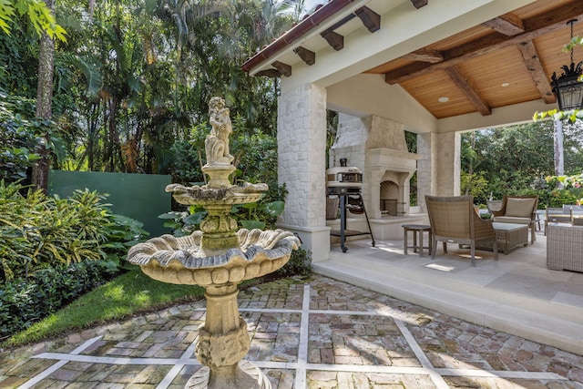 view of patio / terrace featuring an outdoor stone fireplace