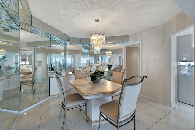 tiled dining space with a textured ceiling, washer and dryer, and a chandelier