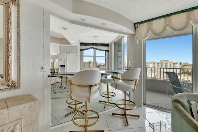 tiled dining space featuring a textured ceiling