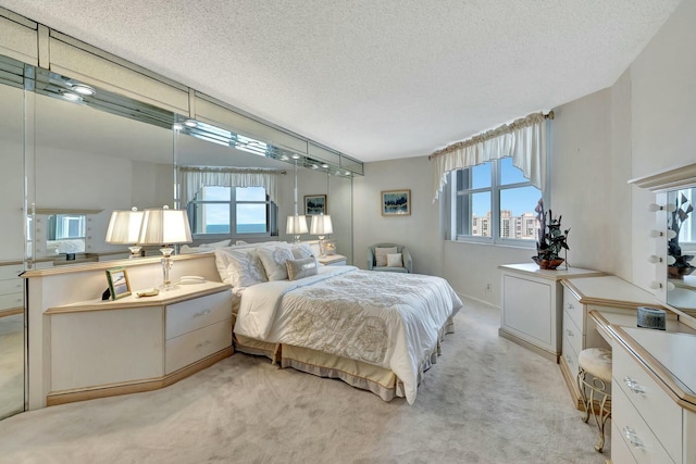 bedroom with a textured ceiling and light carpet