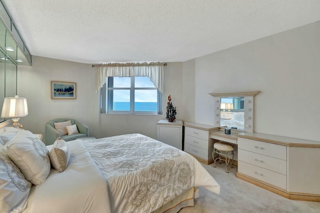 bedroom with light colored carpet and a textured ceiling