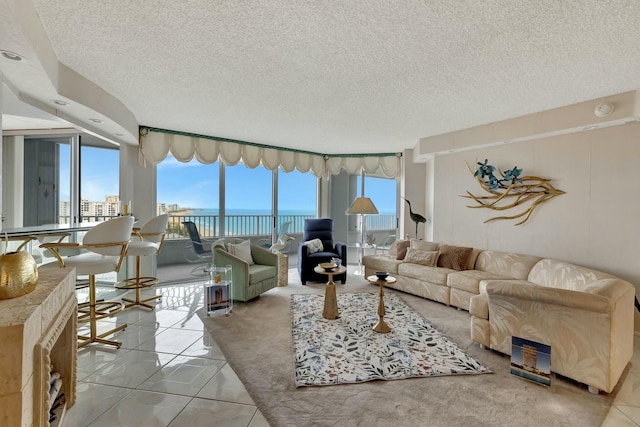 tiled living room with a textured ceiling and a water view