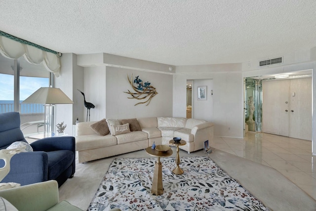 tiled living room featuring a textured ceiling