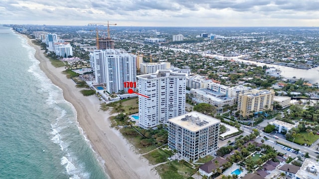 birds eye view of property featuring a beach view and a water view