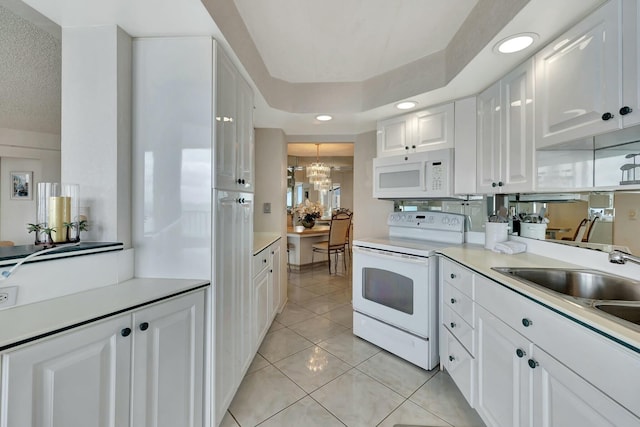 kitchen featuring sink, an inviting chandelier, white appliances, white cabinetry, and light tile patterned floors