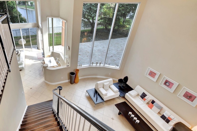 tiled living room featuring a healthy amount of sunlight and a towering ceiling