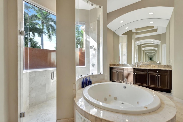 bathroom with plus walk in shower, a wealth of natural light, and vanity