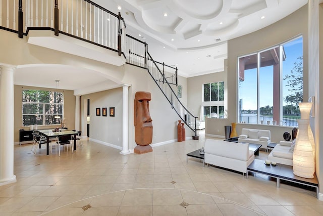 living room featuring a water view, a towering ceiling, plenty of natural light, and coffered ceiling