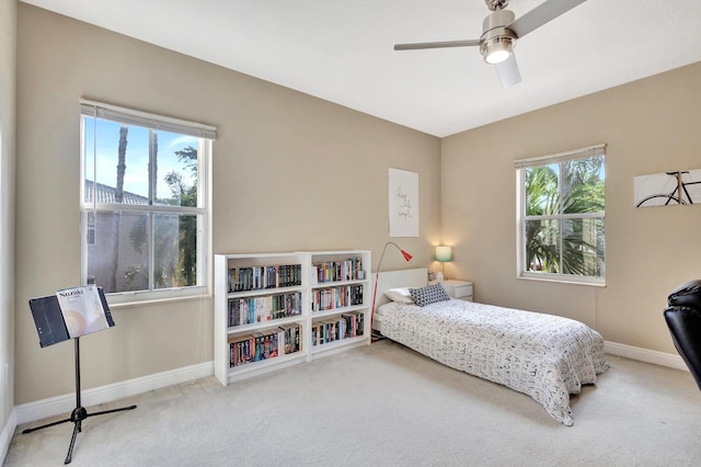 bedroom featuring ceiling fan, carpet, and multiple windows