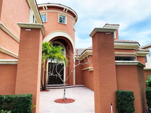 view of exterior entry with a patio