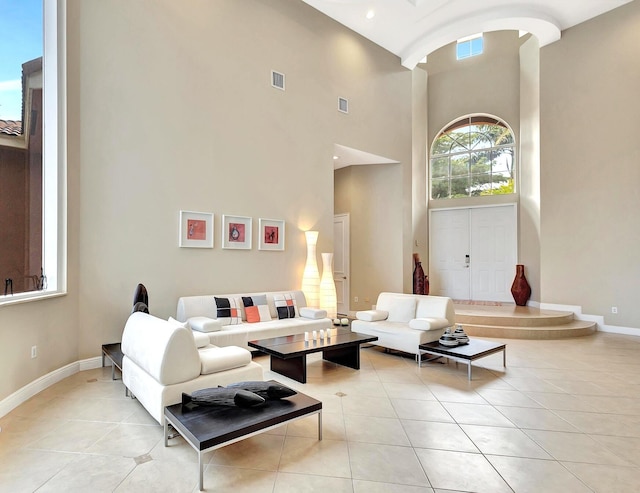 tiled living room featuring a high ceiling