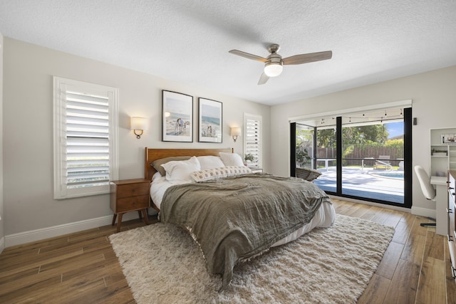 bedroom with dark hardwood / wood-style flooring, multiple windows, ceiling fan, and access to outside