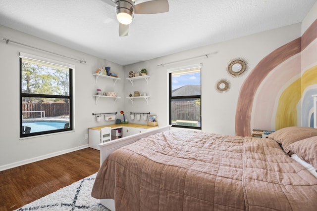 bedroom with hardwood / wood-style flooring, a textured ceiling, and ceiling fan