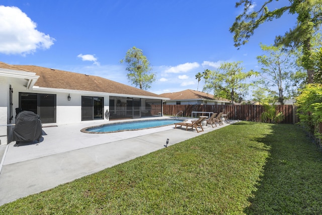 view of swimming pool featuring a lawn, a sunroom, and a patio