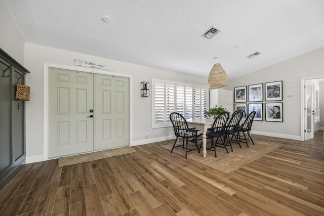 dining room with a textured ceiling and wood-type flooring