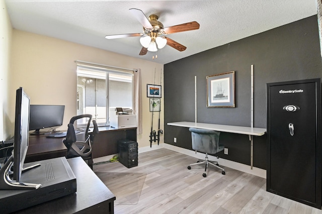 office with ceiling fan, light wood-type flooring, and a textured ceiling