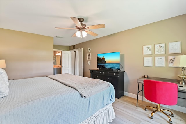 bedroom with light wood-type flooring, ceiling fan, and ensuite bath